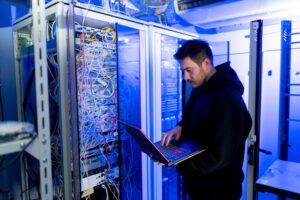 focused hacker in data center hacking software system vulnerable cyber security server room